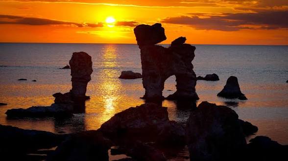Raukar i havet vid solnedgång på Gotland